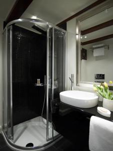 een badkamer met een douche en een witte wastafel bij Porto Vitilo Boutique Hotel in Karavostasion
