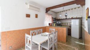 eine Küche mit einem Tisch und Stühlen sowie einem Kühlschrank in der Unterkunft El Castillo Puebla de Los Infantes by Ruralidays in La Puebla de los Infantes