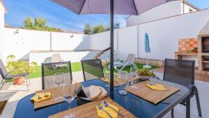 stół z 2 krzesłami i parasol na patio w obiekcie Casa Verde de Elena Benalauría by Ruralidays w mieście Benalauría