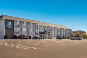 ein großes Gebäude mit Autos auf einem Parkplatz in der Unterkunft Sleep Inn & Suites Clarion, PA near I-80 in Clarion