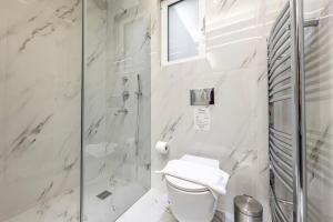 een witte badkamer met een douche en een toilet bij Phaedrus Living City Center Luxury Flat Neos Kosmos in Athene