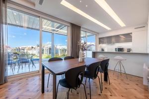 een keuken en eetkamer met een tafel en stoelen bij Phaedrus Living City Center Luxury Flat Neos Kosmos in Athene
