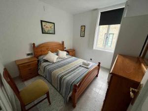 1 dormitorio con 1 cama, 1 silla y 1 ventana en Apartamento A en Irijoa