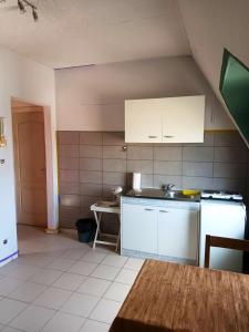 a kitchen with white cabinets and a sink and a refrigerator at Studio with city view at Saint Nicolas in Ans