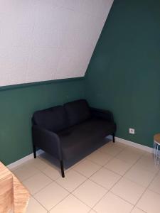 un sofá negro en una habitación con una pared verde en Studio with city view at Saint Nicolas en Ans