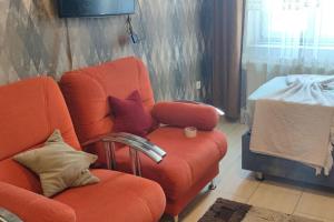 een woonkamer met een oranje bank en een stoel bij Midtown Hotel Apartments 404 ( 2+1) in Istanbul