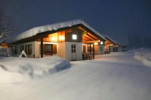 a house covered in snow at night at BergAufe Chalets Mallnitz in Mallnitz