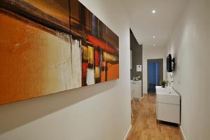 a hallway with paintings hanging on a wall at San Polo Design Apartments by Wonderful Italy in Venice