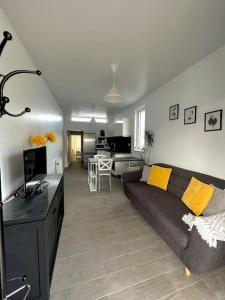 a living room with a couch and a kitchen at Newly renovated 1 bedroom flat with garden pergola in Ennis