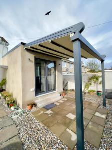 a patio with a canopy in front of a house at Newly renovated 1 bedroom flat with garden pergola in Ennis