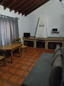 ein Wohnzimmer mit einem Sofa und einem Herd in der Unterkunft DEHESA LAS BRIDAS, SL in Morón de la Frontera