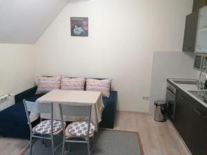 a small kitchen with a table and chairs in a room at BOROVETS Royal Plaza - A409 in Borovets