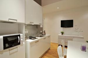 a white kitchen with a sink and a microwave at San Polo Design Apartments by Wonderful Italy in Venice