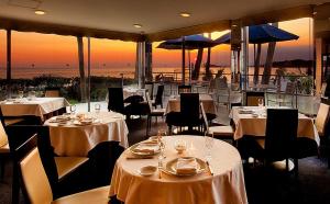 逗子市にあるMALIBU HOTELの海の景色を望むテーブルと椅子付きのレストラン