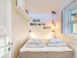 a small bed in a small room with a window at Holiday home Jægerspris XLIII in Jægerspris