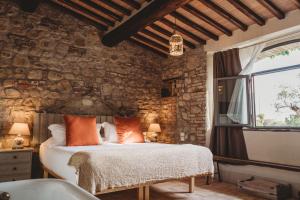 a bedroom with a bed and a stone wall at Locanda in Tuscany in Castiglione dʼOrcia
