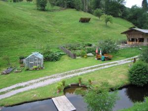 einen kleinen Garten mit einer Brücke über den Fluss in der Unterkunft Schembachhof in Bad Rippoldsau