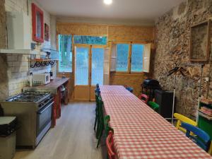 a kitchen with a table with a red and white checkered table cloth at Can Resiu in Serinyà