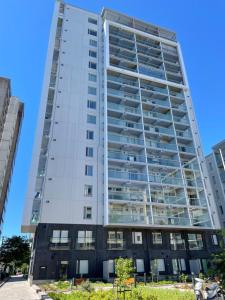 un edificio blanco alto con muchas ventanas en STAY Matinkylä Apartments, en Espoo