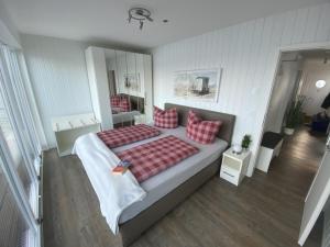 a bedroom with a large bed with red pillows at Hausboot ANTARES ONE by Seeblick Ferien ORO in Olpenitz