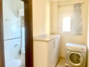 a bathroom with a washing machine and a shower at Amazing Beachfront townhouse chalet Ain Sokhna LaVista 1 in Ain Sokhna