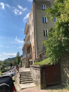 un edificio con escaleras y un coche aparcado delante de él en Apartment BB II nad Deptakiem, en Krynica-Zdrój