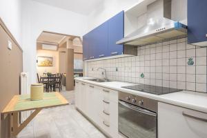 a kitchen with blue cabinets and a table in it at Pegasus Apartment in Piraeus