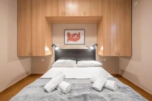a bedroom with a large bed with wooden cabinets at Pegasus Apartment in Piraeus