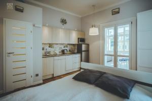 a bedroom with a large bed and a kitchen at Art Nouveau Weranda in Sopot
