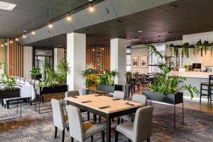 um restaurante com mesa, cadeiras e plantas em Hotel IOR em Poznań