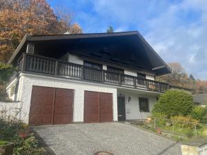 a house with two garage doors and a balcony at Ferienhaus Eifelblick in Feusdorf