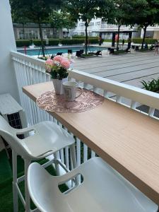 uma mesa com duas cadeiras e uma mesa com flores em Trees Residence in Quezon City with balcony. em Manila