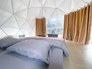 ein Schlafzimmer mit einem großen Bett in einem Zelt in der Unterkunft ธาราไลฟ์ in Ratchaburi
