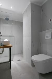 a white bathroom with a toilet and a sink at Club Zante Plaza in Laganas