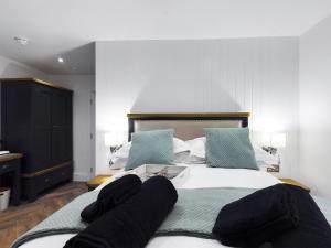 a bedroom with a bed with a book on it at Driftwood Boutique Guest House in Rhosneigr
