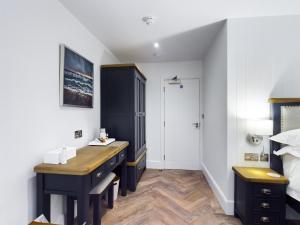 a bedroom with a desk and a bed at Driftwood Boutique Guest House in Rhosneigr