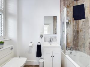 uma casa de banho com um lavatório, uma banheira e um WC. em Driftwood Boutique Guest House em Rhosneigr
