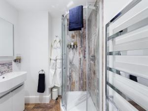 a bathroom with a shower and a sink at Driftwood Boutique Guest House in Rhosneigr