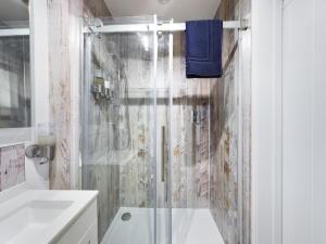 a white bathroom with a shower and a sink at Driftwood Boutique Guest House in Rhosneigr