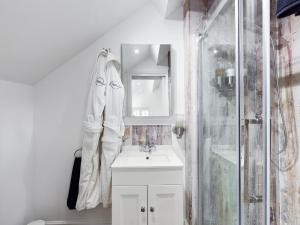 a white bathroom with a sink and a shower at Driftwood Boutique Guest House in Rhosneigr