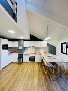 a kitchen with a table and chairs in a room at TRIPLEX 8 COUCHAGES - BONASCRE AX LES THERMES in Ax-les-Thermes