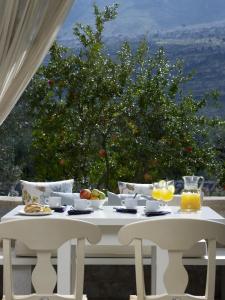 a white table with food and fruit on it at Porto Vitilo Boutique Hotel in Karavostasi