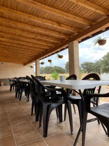 - une rangée de tables et de chaises sur la terrasse dans l'établissement CASA RURAL LA HOJA EL VALLE, à Valdecaballeros
