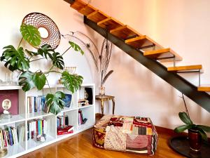 a living room with a book shelf and stairs at House of Alchemy in Bologna
