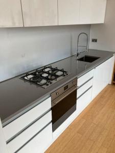 a kitchen with a stove top and a sink at Loft in Haggerston in London