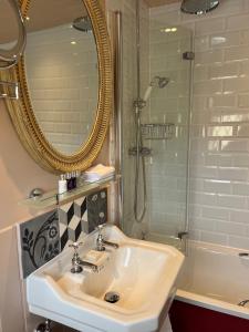 a bathroom with a sink and a mirror and a shower at The Broadway Hotel in Broadway