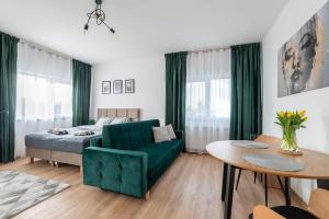 - un salon avec un canapé vert et un lit dans l'établissement Apartamenty RIO Skarbimierz-Osiedle, à Skarbimierz Osiedle
