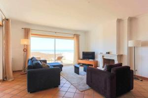 a living room with two couches and a television and a living room at T2 Terraço Privativo vista mar Praia del Rey A1 in Amoreira