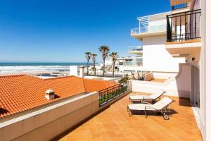 a balcony of a building with a view of the beach at T2 Terraço Privativo vista mar Praia del Rey A1 in Amoreira