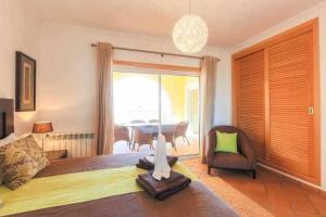 a bedroom with a bed and a chair and a table at T2 Terraço Privativo vista mar Praia del Rey A1 in Amoreira +29 photos